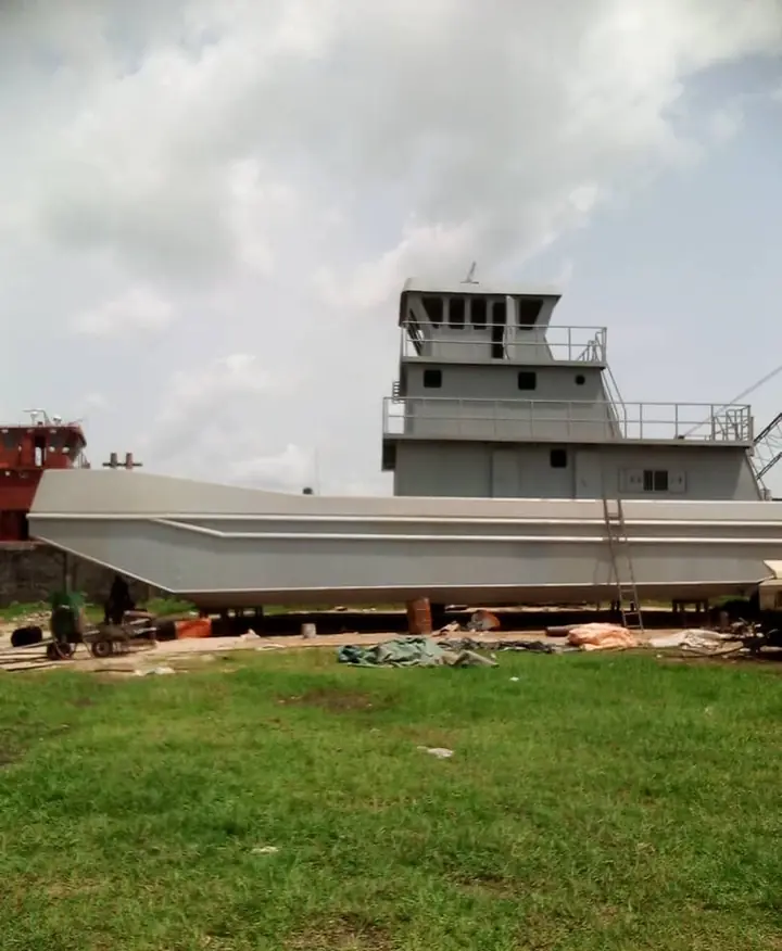 Tugboat hull and wheelhouse under construction in a marine yard